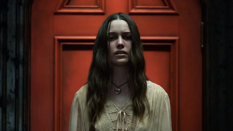 Victoria Pedretti as Nell standing in front of red door in The Haunting of Hill House