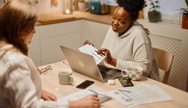 Two people looking at paperwork on the kitchen table.