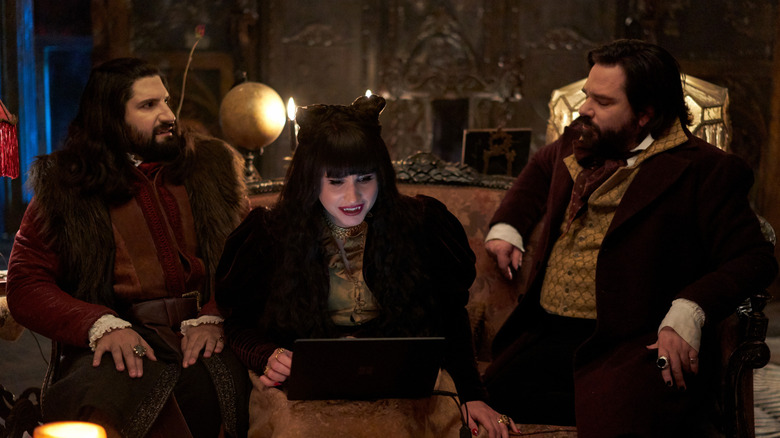 Laszlo, Nandor, and Nadja sitting on the couch with a laptop