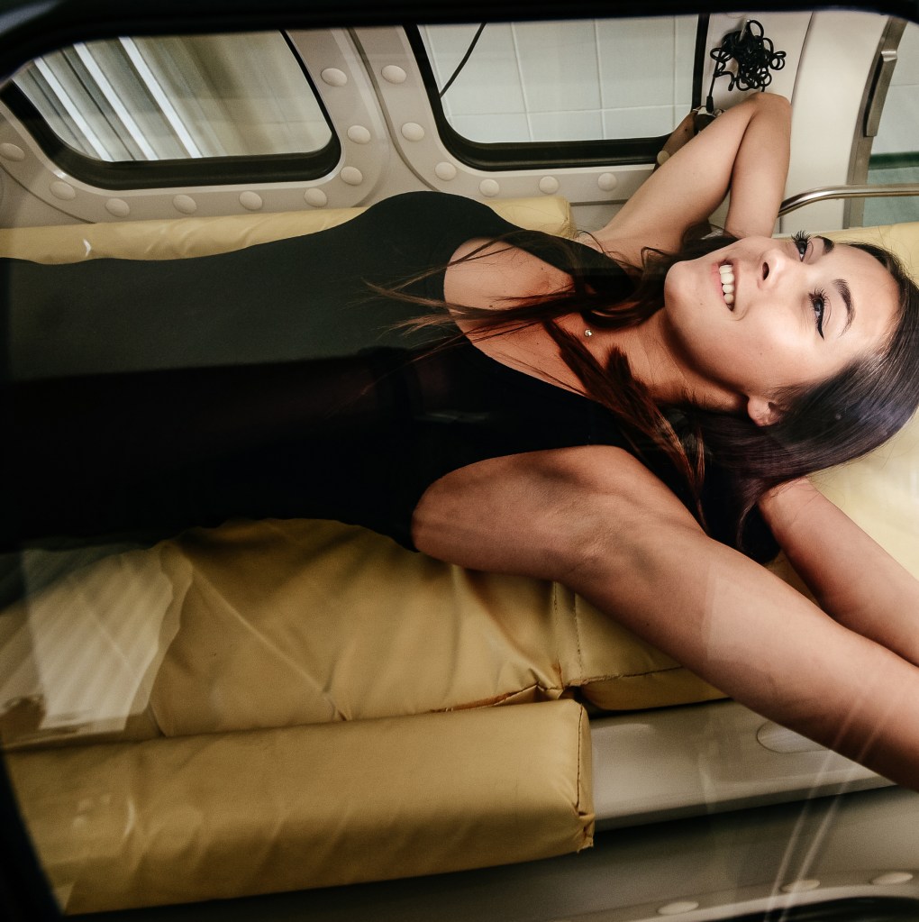 A woman lies inside an oxygen pressure chamber for medical treatment.