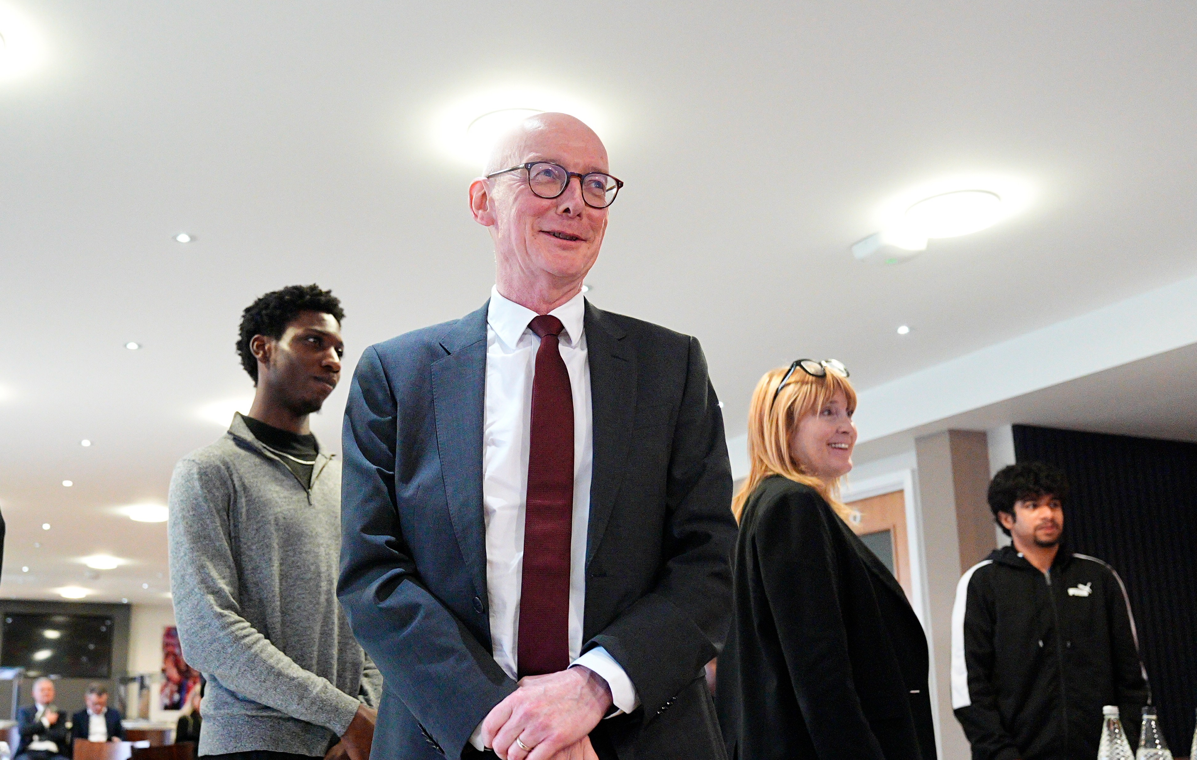 Pat McFadden, Work and Pensions Secretary, standing in a room with several young people during a visit to Crystal Palace FC's youth hub at Selhurst Park.