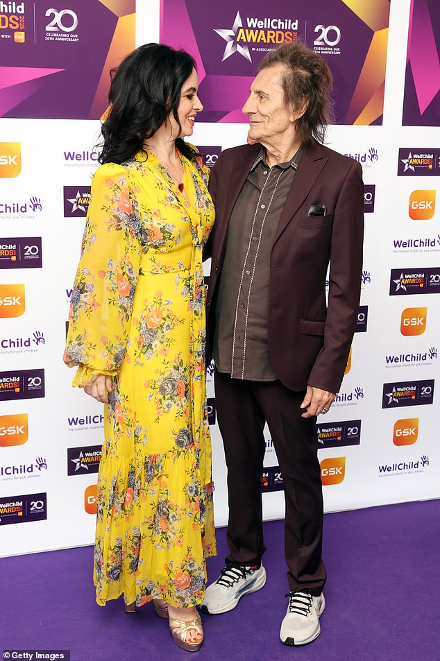 Sally cut a stylish figure in a chic yellow floral dress as she posed with husband of 13 years Ronnie at the awards