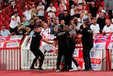 thumbnail: A Serbia fan is apprehended by security in front of the England fans during the World Cup qualifier at Rajko Mitic Stadium in Belgrade.