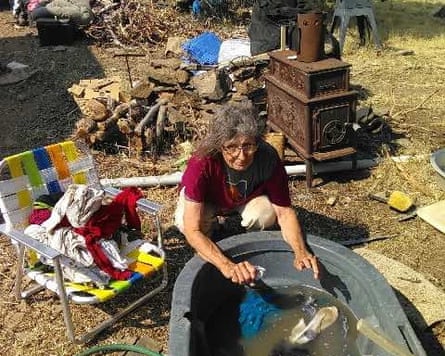 A woman doing laundry by hand outside in a tub