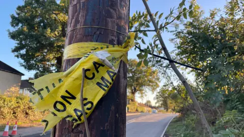 Steve Beech/BBC A telegraph pole with a yellow "caution" ribbon wrapped around it