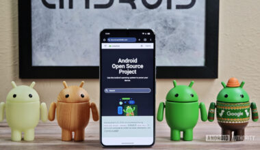 Android figures standing around Pixel phone with AOSP home page showing