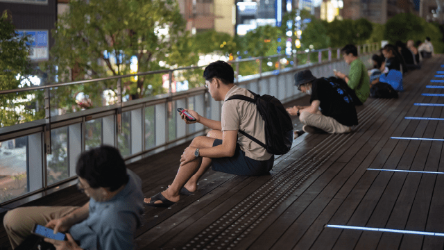 People use smartphones in Tokyo’s Akihabara district in September 2024. (Tomohiro Ohsumi/Getty Images)