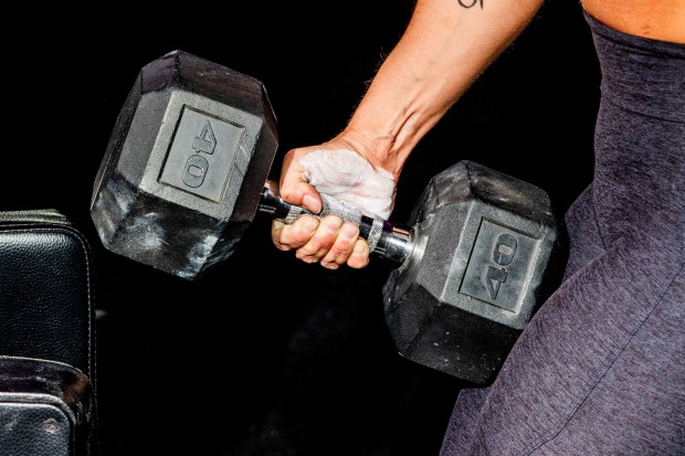 Racheal Belen clutches a 40-pound dumbbell. (Roger Kisby / The New York Times)