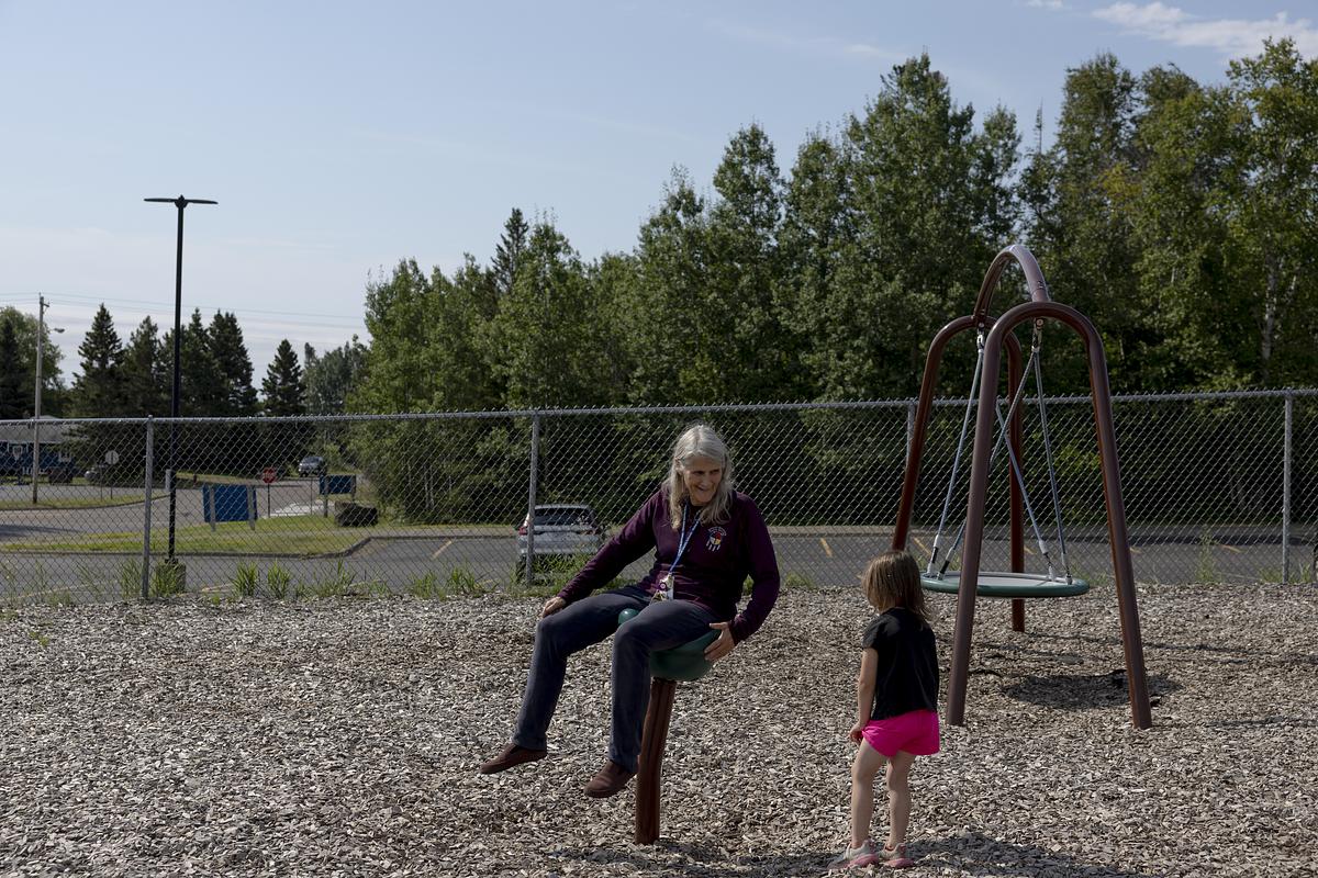 Lisa Sater plays with a kid on the playground