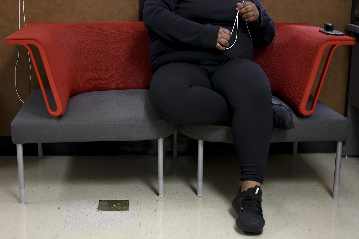 A student fidgets with pull cords on blinds