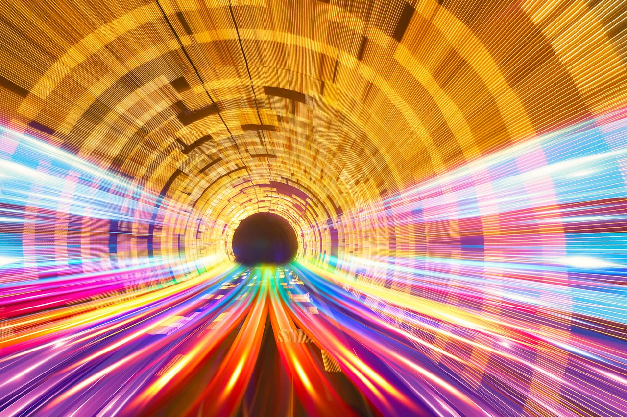 Mesmerizing view of high-speed motion blur in a futuristic tunnel representing communication, creating vibrant light trails that form colourful streaks, representing rapid communication and seamless data transfer in the modern digital landscape.