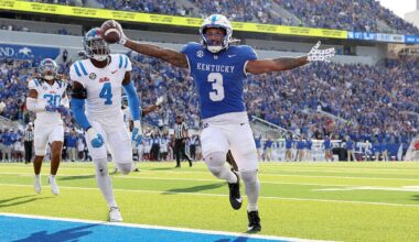 Football player Seth McGowan #3 of the Kentucky Wildcats, in dark blue, runs for a touchdown against the Ole Miss Rebels.