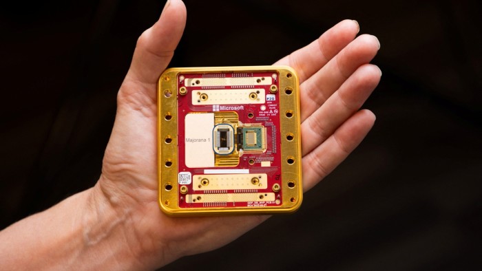 A hand on a black background holding up Microsoft’s Majorana 1 quantum computing chip