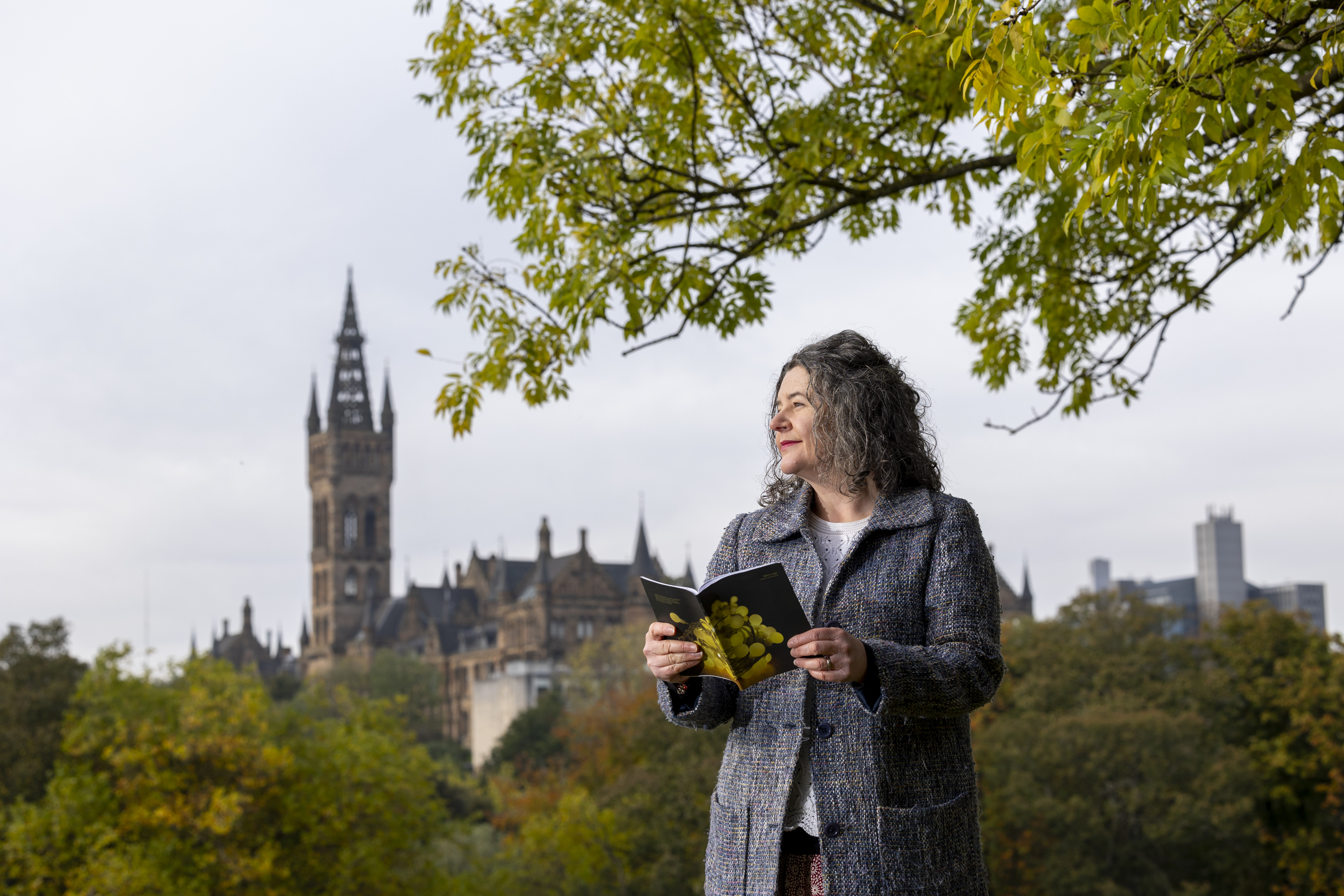 Professor Hester Parr in Kelvingrove Park with the University of Glasgow building in the background.