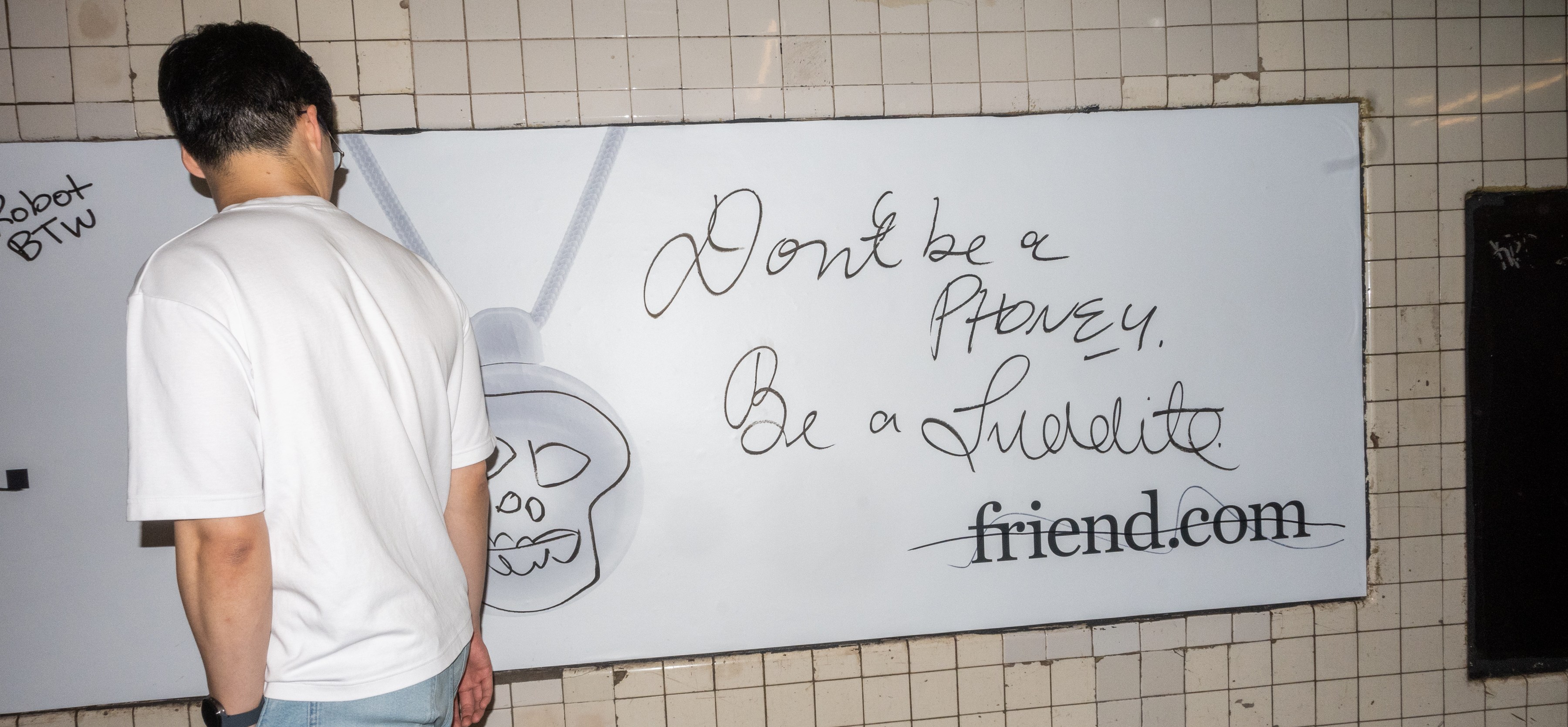 A person looks at a subway advertisement sign with graffiti.