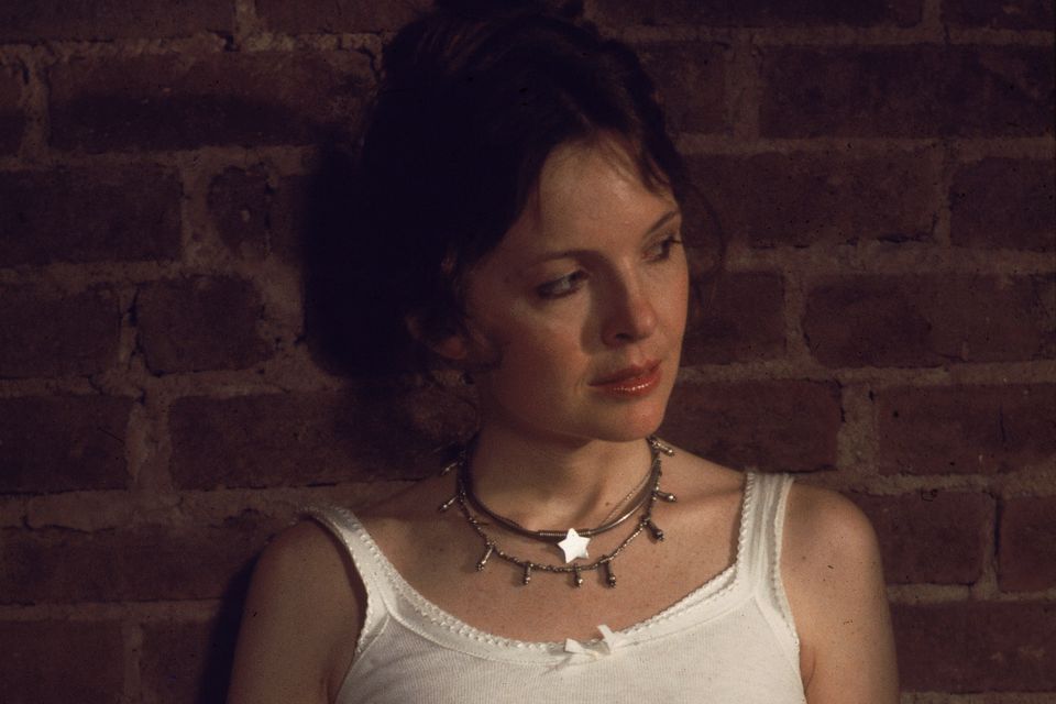 American actor Diane Keaton wears a white tank top and leans against a brick wall in a scene from 'Annie Hall,' directed by Woody Allen, New York, New York, 1977. (Photo by United Artists/courtesy of Getty Images)