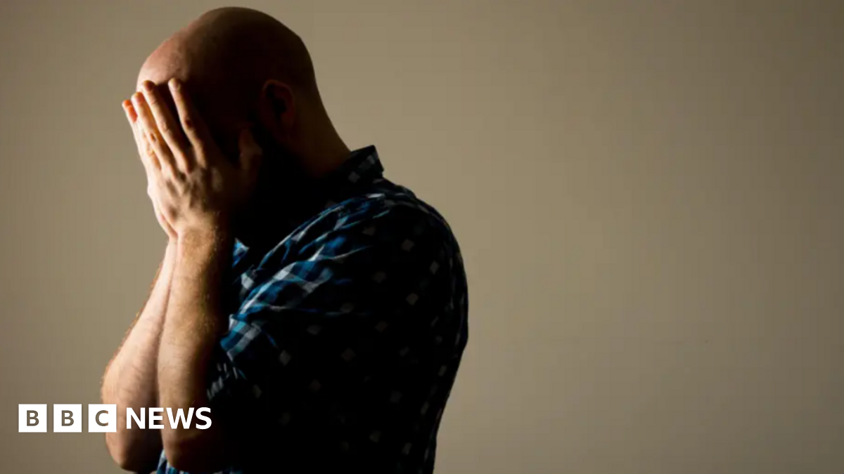 A stock image of a man with his head in his hands.