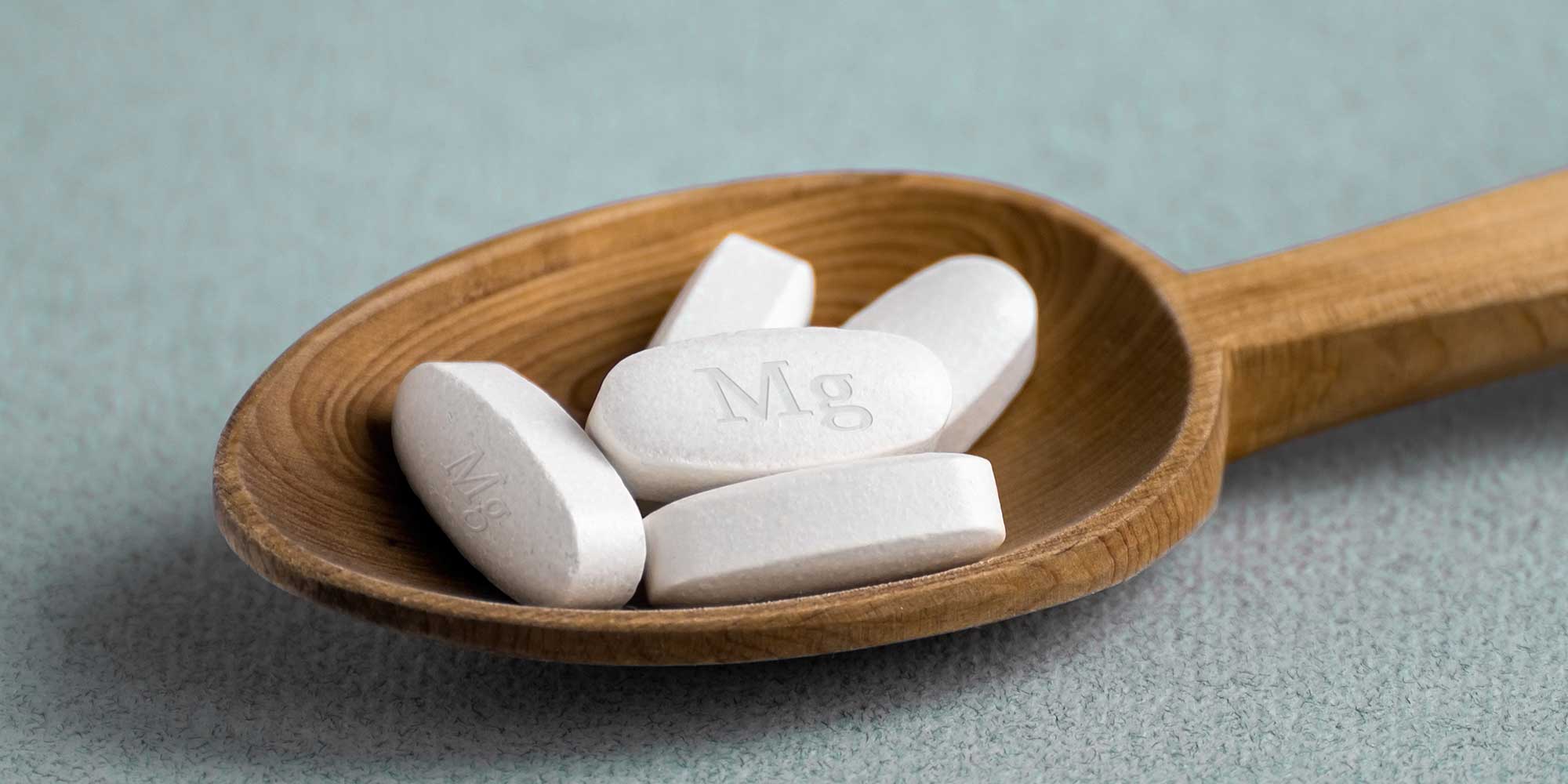 Magnesium pills in a wooden spoon