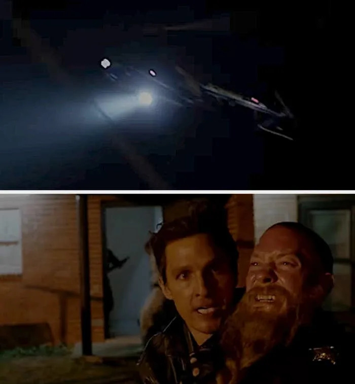 A helicopter shines a spotlight in the dark. Below, a tense scene shows two men, with one restraining the other outside a building