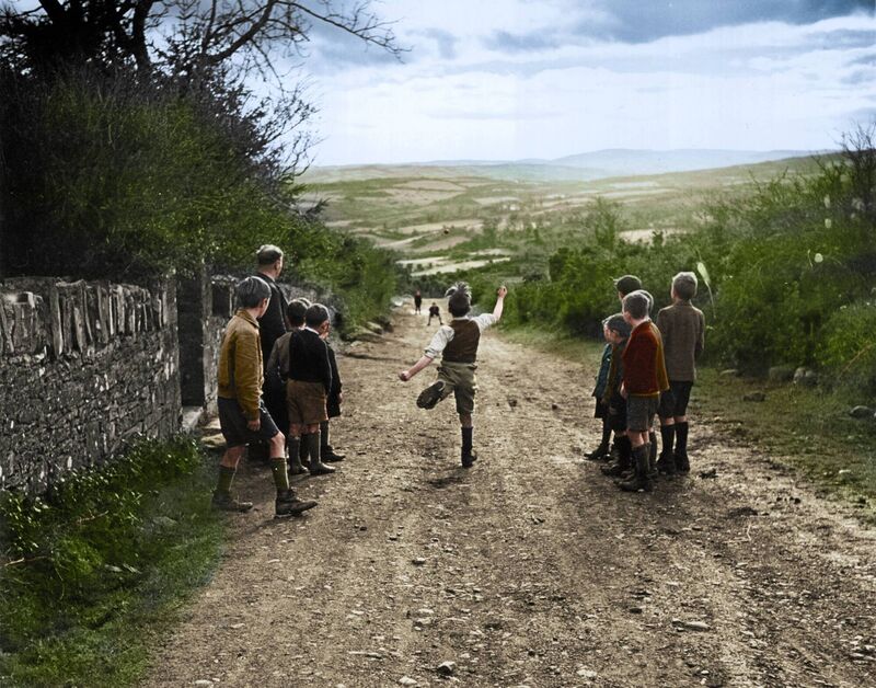 A young boy, along with his friends, enjoys a game of road bowling A young boy, along with his friends, enjoys a game of road bowling