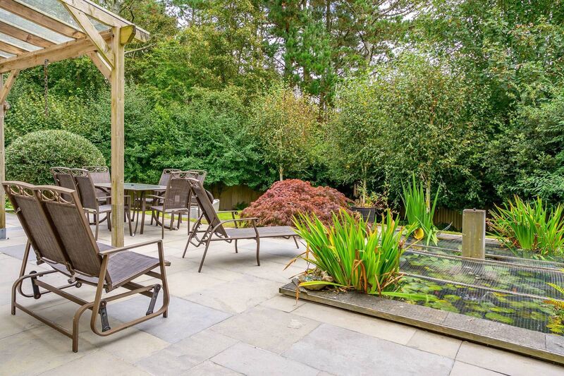 A fish pond is embedded in the patio and stocked with koi carp and goldfish