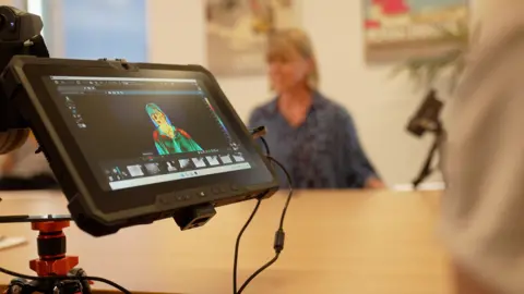 Kevin Church/BBC News a video camera viewfinder shows the correspondent's thermal image while the correspondent herself is blurred out in the background.