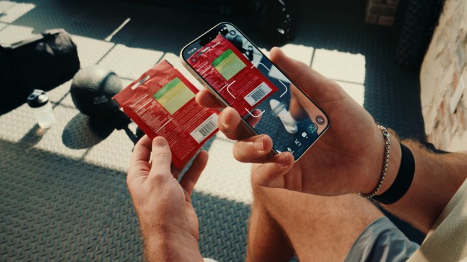 A lifestyle image of Ladder app's new nutrition tracking feature that shows a person scanning barcode of a food item to get information about macros