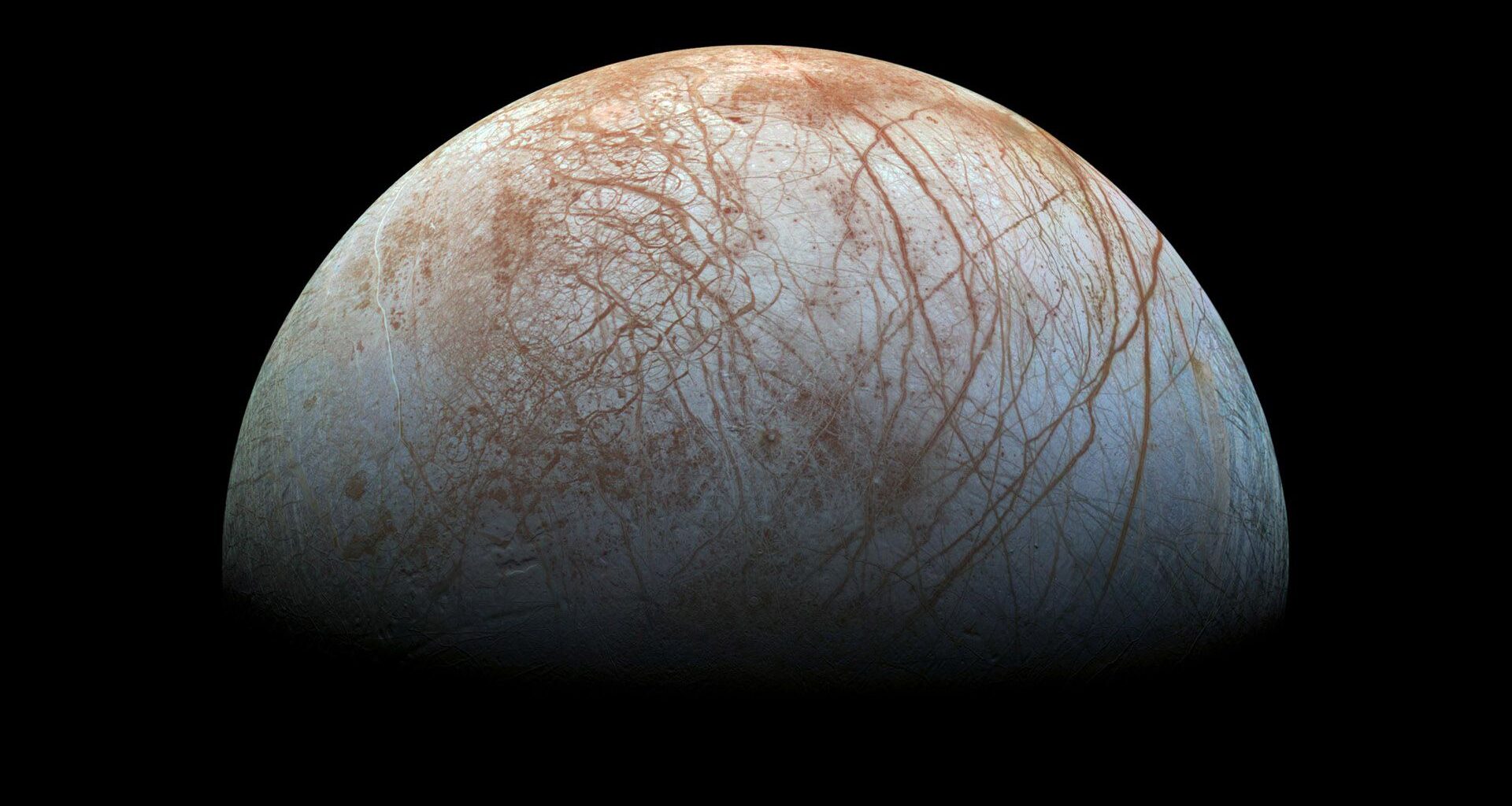 an ice-covered moon in deep space, whose surface is criss-crossed by snaking brownish stripes