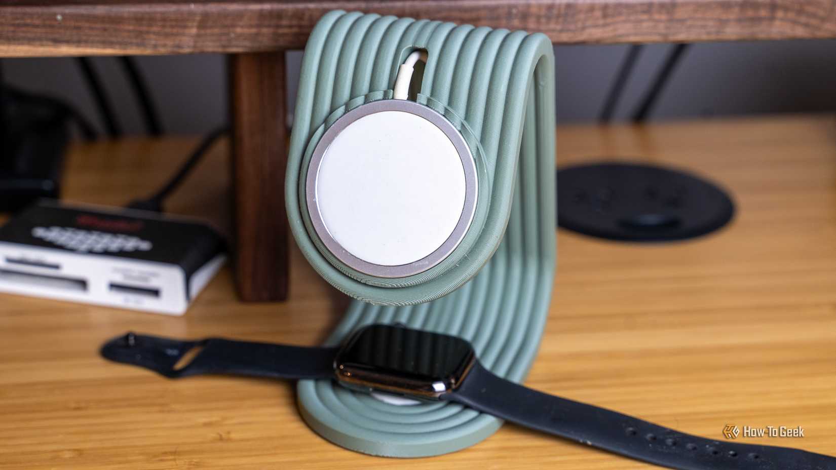 A 3D printed MagSafe stand that also charges an Apple Watch sitting on a bamboo desk.
