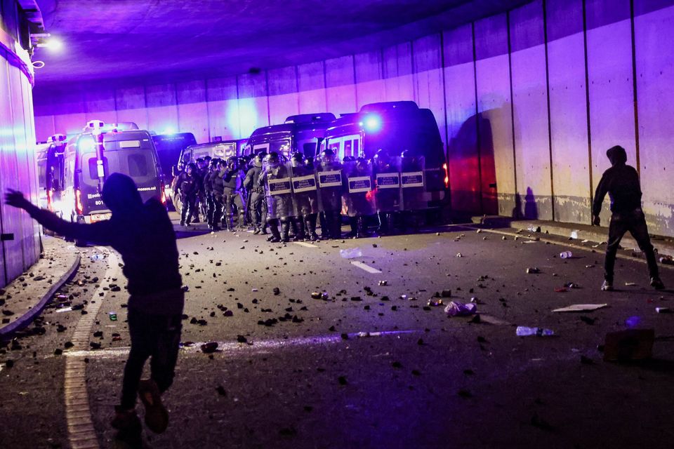 Pro-Palestinian demonstrators throw stones at riot police officers during a protest to condemn the Israeli forces' interception of vessels of the Global Sumud Flotilla aiming to reach Gaza and break Israel's naval blockade, near the port of Barcelona, Spain October 2, 2025. REUTERS/Nacho Doce
