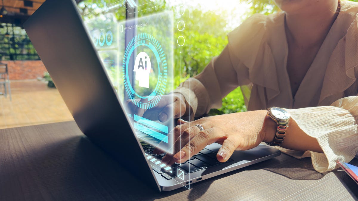 A woman types on a laptop with an AI background next to a field.