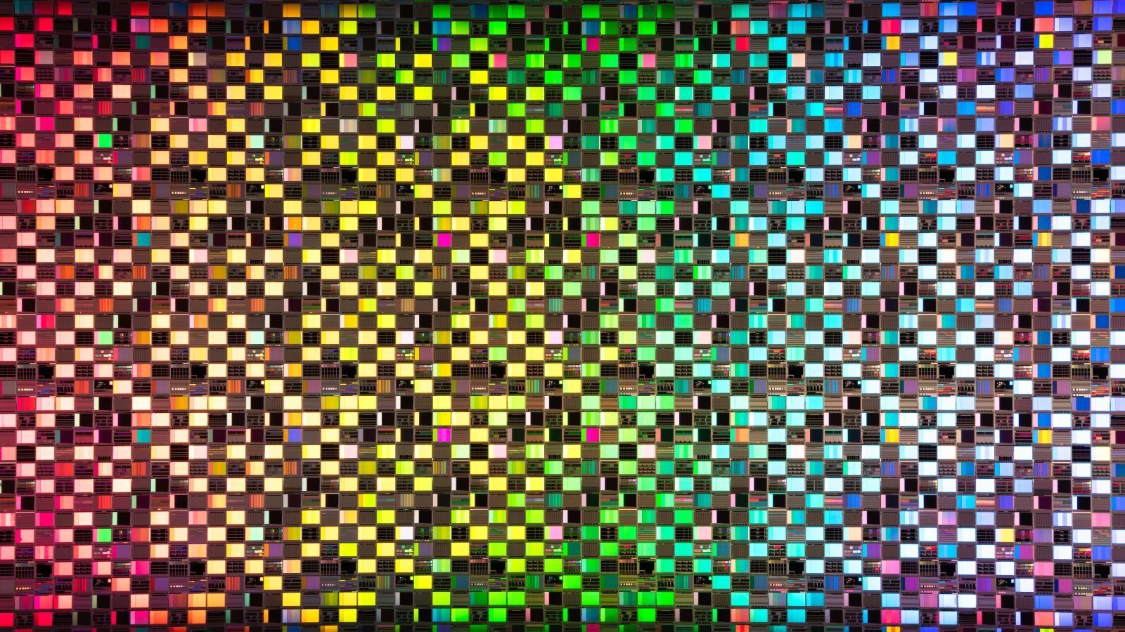 Rainbow colored iridescent semiconductor wafer extreme close-up studio shot.