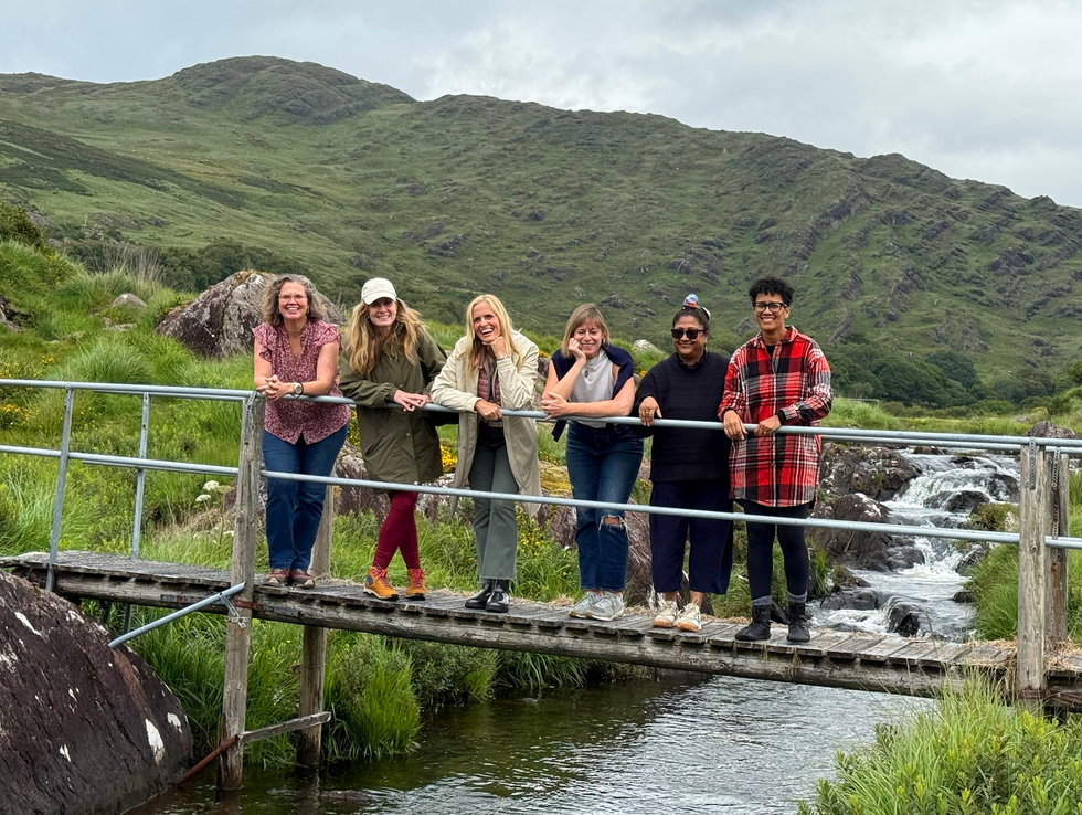 six women standing on a bridge