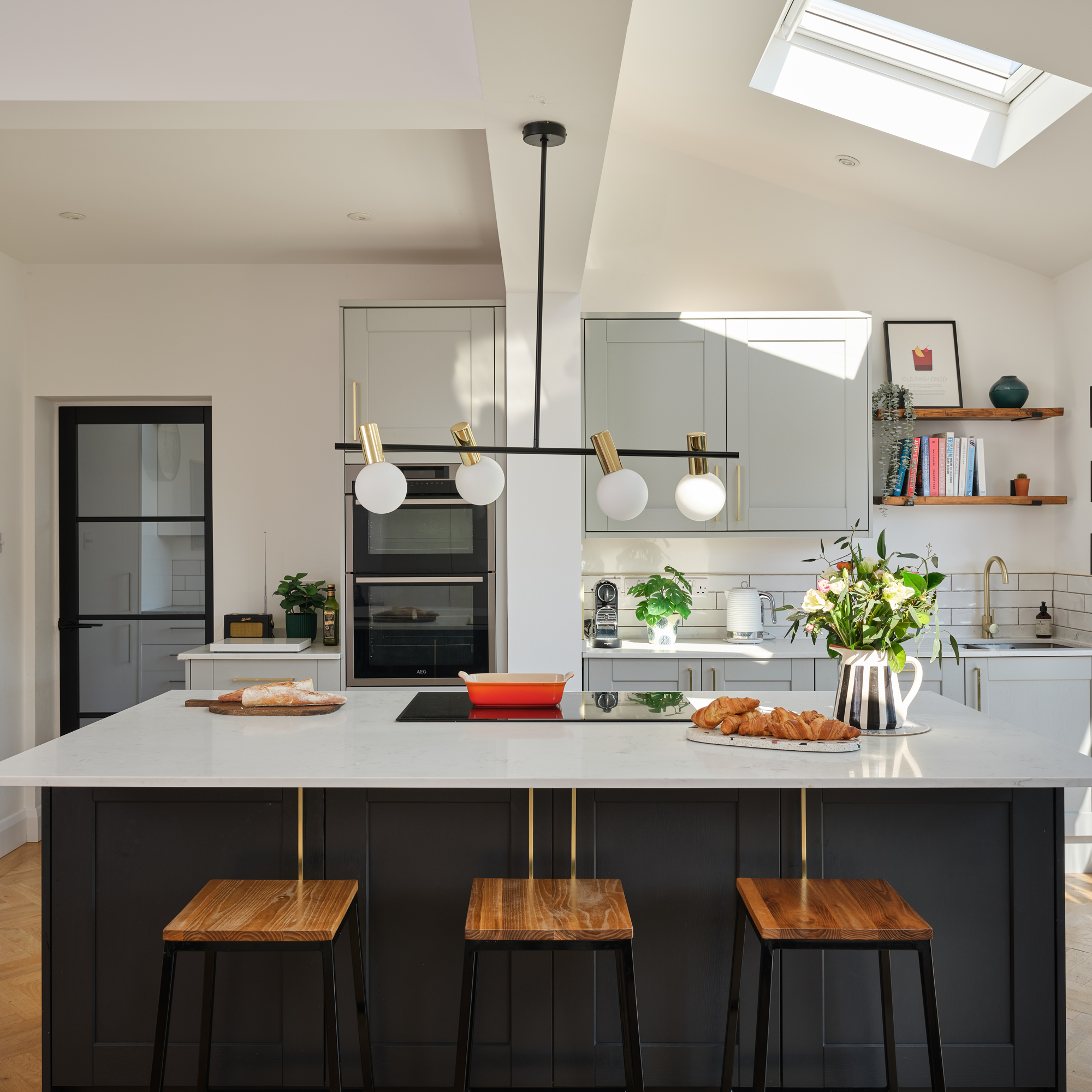 large neutral kitchen with kitchen island and breakfast bar, skylight and pendant light over island