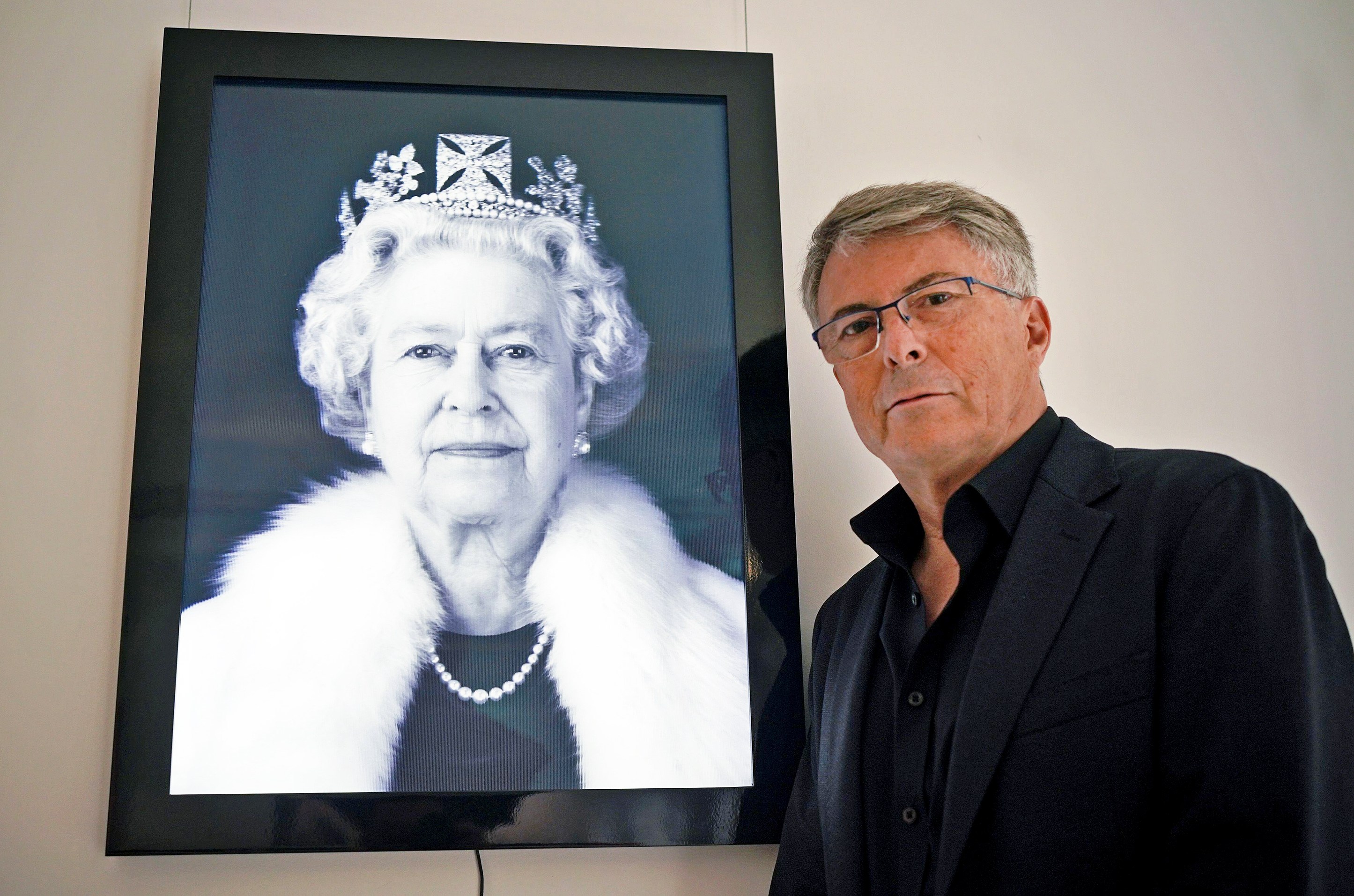 Rob Munday next to his portrait of Queen Elizabeth II.