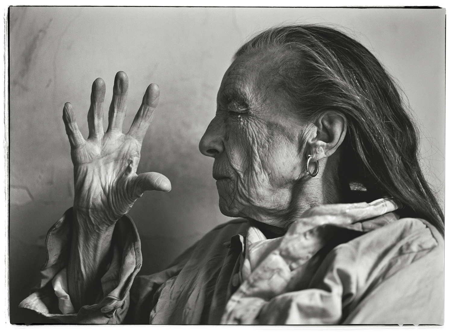 Louise Bourgeois, sculptor, raising her hand to her face.