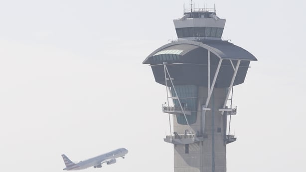 A view of the air traffic control tower as a plane passes it at Los Angeles International Airport in California.