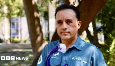 Mauricio Hoyos looks at the camera, while holding a wave-shaped award