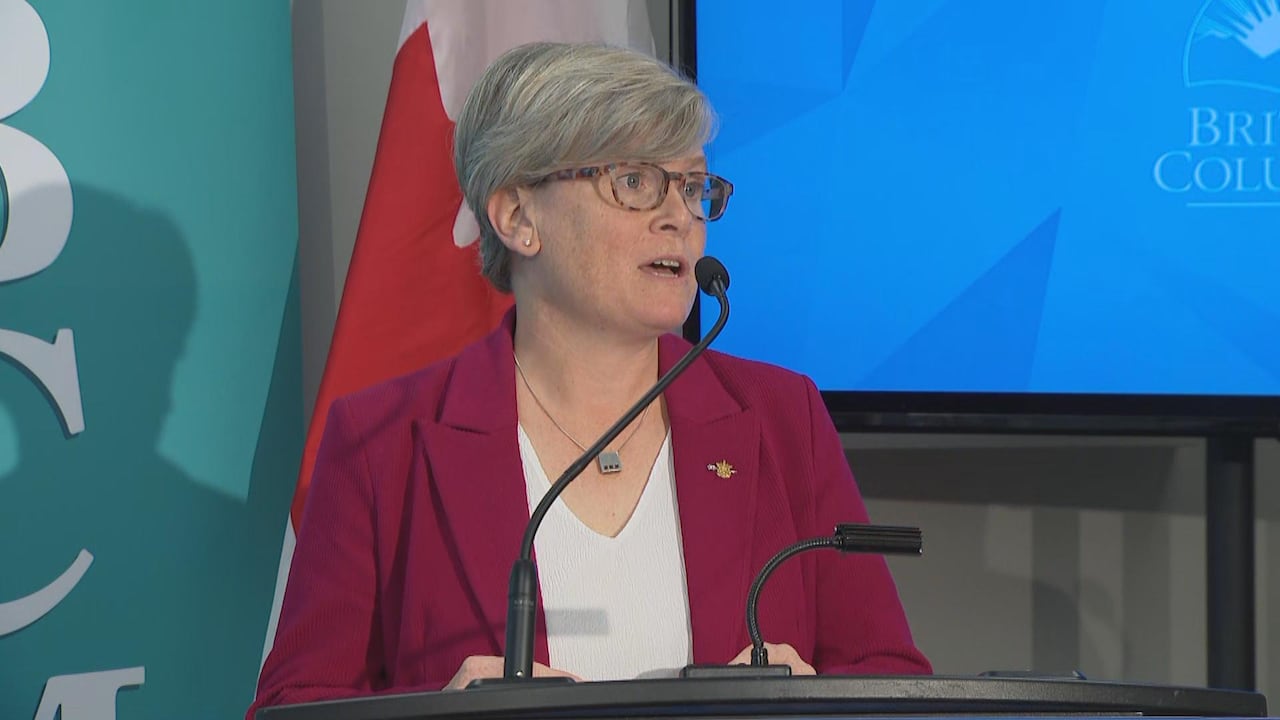 A woman in a blazer speaks at a news conference