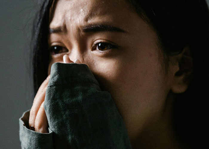 Close-up of a psychiatric institution worker overwhelmed with emotion, reflecting unforgettable moments experienced on the job.