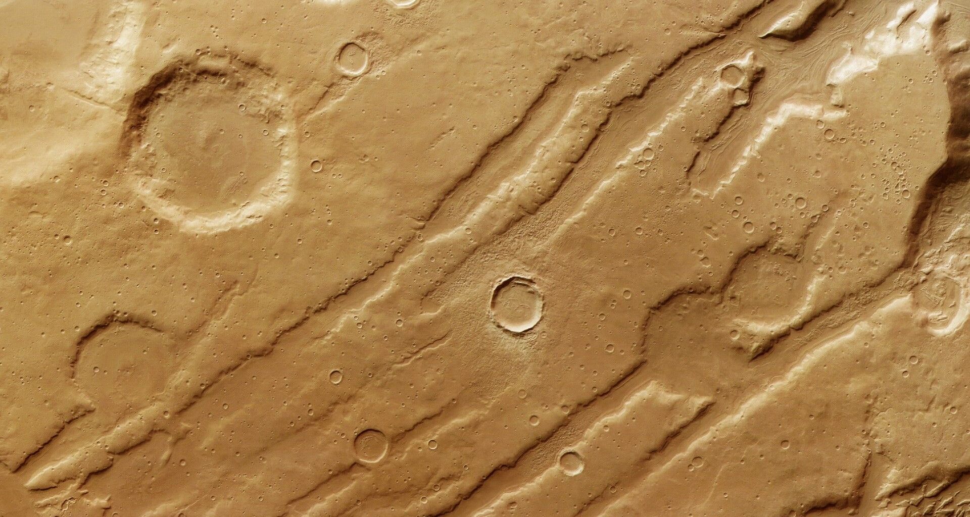 gouges and craters in a reddish orange landscape as seen from overhead