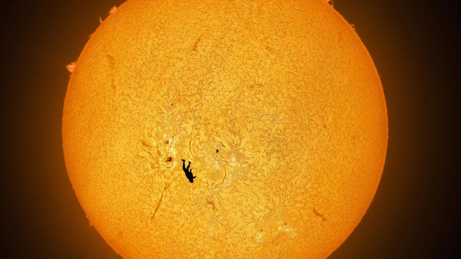 Photo of the sun with the silhouette of a skydiver in front