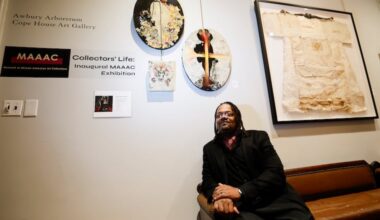 Art collector William Skeet Jiggetts sits near artwork he has collected during the Museum of African American Art Collections inaugural exhibit at the Awbury Arboretum in East Germantown.