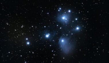A series of bright blue and white stars shine in a deep space image