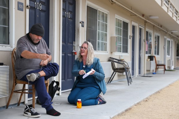 Jesika Quintal, right, a medical assistant and patient navigator for Providence Mobile Health Clinic, helps Jason Nunes organize his medication during a visit at Studios at Montero supportive housing in Petaluma on Monday, Sept. 29, 2025. (Christopher Chung/The Press Democrat)