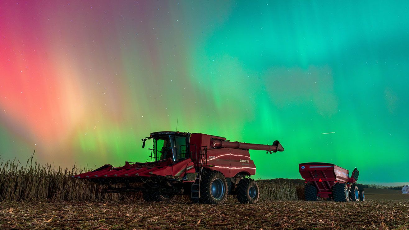 Solar Storm Lights Up Wisconsin Farmland with a combine harvester In Rare Aurora Spectacle