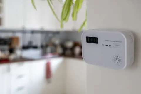 Getty Images White carbon monoxide detector positioned on kitchen wall, ready to monitor air quality and ensure safety