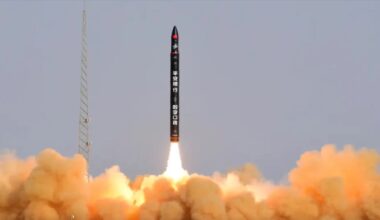 a black rocket launches into a bluish sky