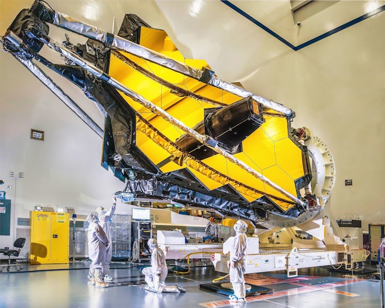 The James Webb space telescope inside a huge hangar like building.