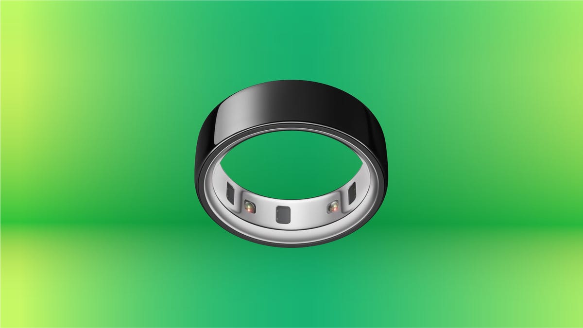 Black Oura Ring on display against green gradient background.